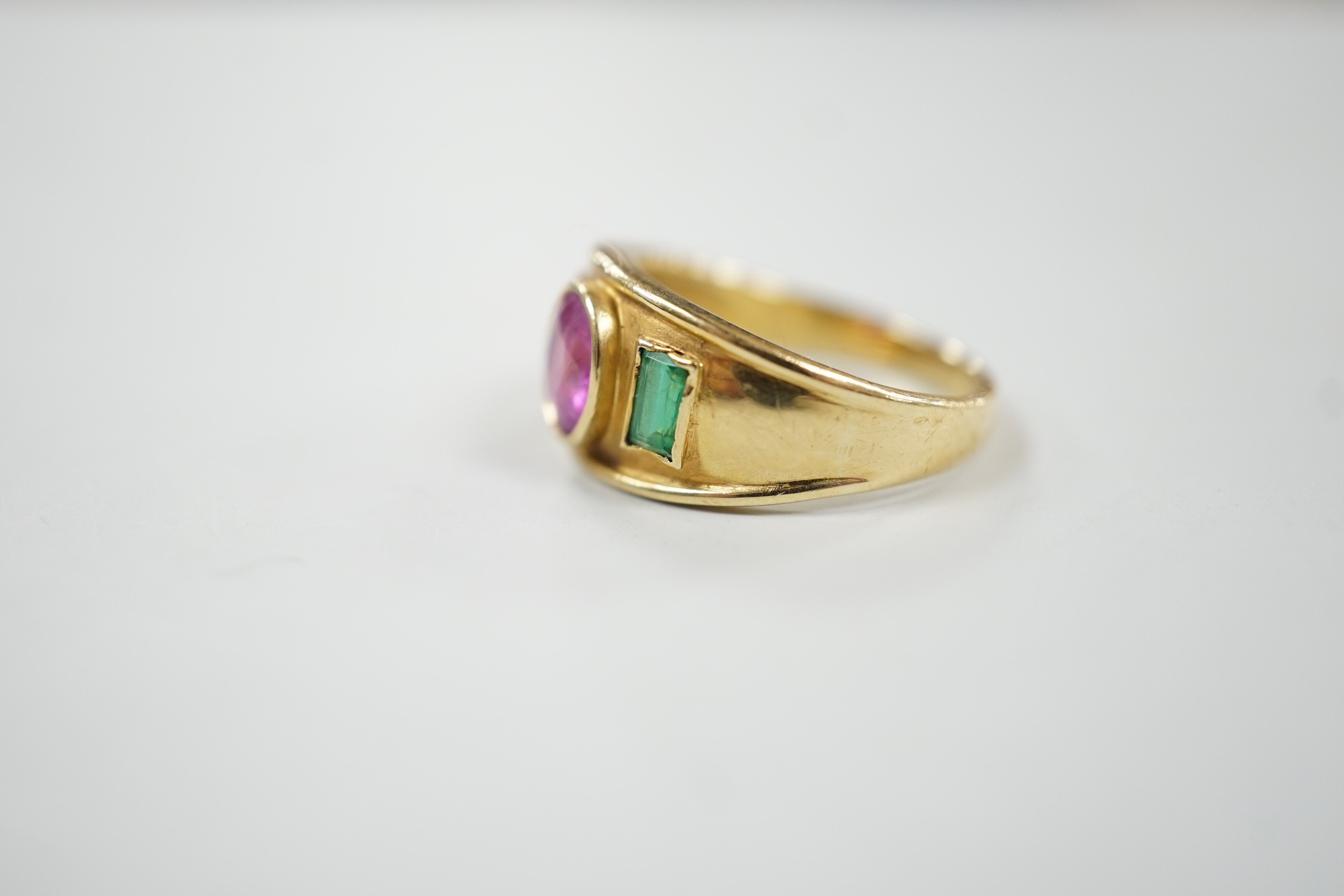 A modern 14k, collet set ruby and green paste? three stone ring, size L, gross weight 4 grams.